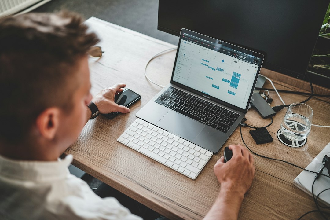 Professional using laptop and smartphone for business software and finance